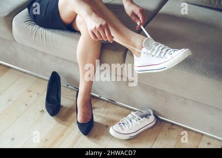 woman makes the choice between comfortable and uncomfortable shoes Stock Photo