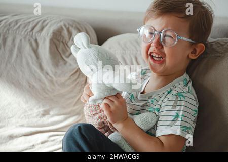 Child with autism hugs a toy, cries and gets angry Stock Photo