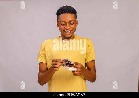 african young man counting his win from a bet Stock Photo