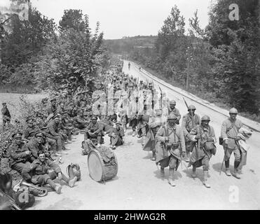 French infantry coming back through Passy-sur-Marne pass British regimental band resting by the roadside, 29 May 1918 during the Battle of the Aisne Stock Photo