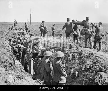 Troops of the 3rd Battalion, Grenadier Guards, in the old German second line during Attack on Moyenneville. There are German prisoners and wounded coming in. Note tanks in distance. 21 August 1918. (Note Lewis gun mounted for use against aircraft). Stock Photo