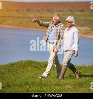 Experiencing all that nature has to offer. Shot of a happy senior couple going for a walk at the lake. Stock Photo