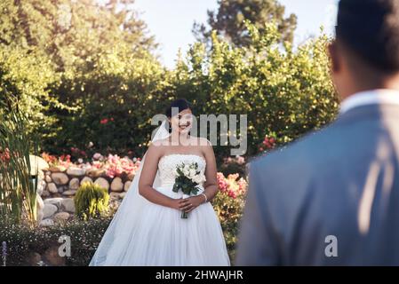 I still feel butterflies whenever hes around. Cropped shot of a happy bride looking at her groom. Stock Photo