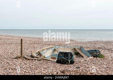 Boat and lobster pots abandoned on the beach Stock Photo