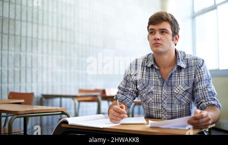 Dedicated to his education. Shot of a young college student studying in class. Stock Photo
