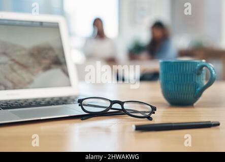 Put your vision into action. Closeup shot of spectacles and a laptop on a table in an office. Stock Photo