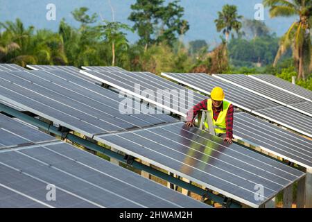 A man working at solar power station, electrician installing solar panels working on alternative energy sources clean, Solar Power. Stock Photo