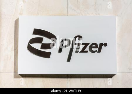 Pfizer sign, logo on the facade of pharmaceutical and biotechnology corporation headquartered on 42nd Street in Manhattan. - New York, USA, 2022 Stock Photo