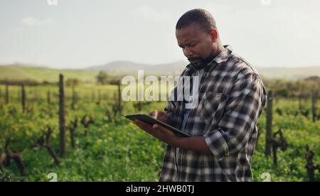 Farming just got a whole lot more efficient. Shot of a mature man using a digital tablet while working on a farm. Stock Photo