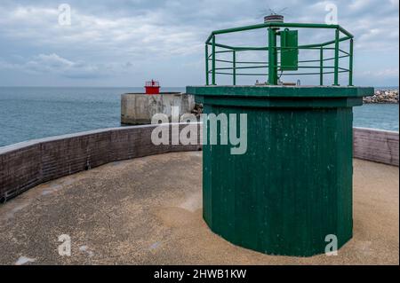 The red and green entrance lights to the port of Marina di Pisa, Italy, on a cloudy day Stock Photo