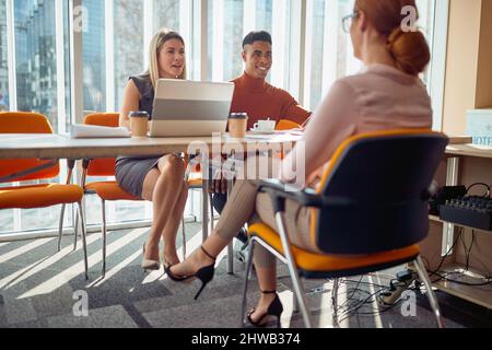 A young female applicant and young commission having a pleasant talk in a relaxed atmosphere during an interview for a job. Business, people, company Stock Photo