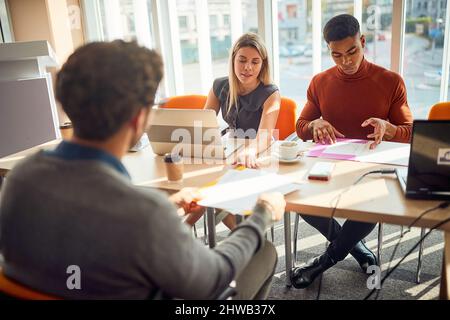 Casual meeting of smiling diverse business team analyzing financial data Stock Photo