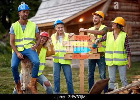 Group of construction workers powerful team. Playful team. Young construction workers together. Wooden Skeleton Framing Building. Construction industr Stock Photo