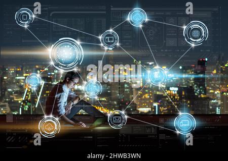 Asian businessman sitting and using the laptop showing Wireless communication connecting of smart city Internet of Things Technology which driving by Stock Photo