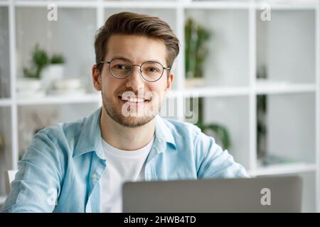 An attractive young man is working on a laptop. Stock Photo
