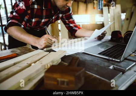 carpenter or architect looking on paper sketch working in site work Stock Photo
