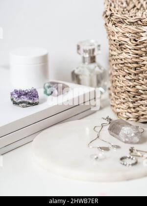 Various items and white marble podium on female dressing table in the white bedroom. White boudoir table close up and copy space. Stock Photo