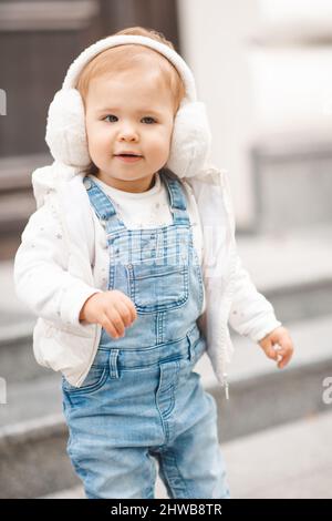 Cute smiling baby girl 1 2 year old wear casual denim pants and white top in city street outdoors. Looking at camera. Childhood. Springtime Stock Photo Alamy