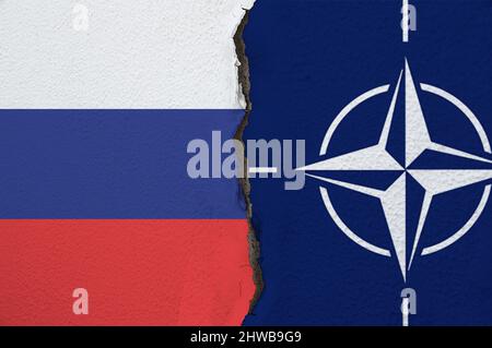 Kyiv, Ukraine - 02/02/2022: Flags of NATO and Russia on the wall with big crack in the middle. Relationships between North Atlantic Treaty Organisatio Stock Photo