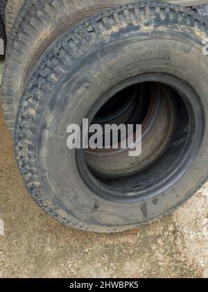 used old truck tyres stacked in a repair shop, closeup Stock Photo