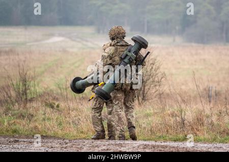 British army soldiers completing an 8 mile combat fitness test tabbing exercise with 40Kg bergen and NLAW (MBT-LAW, RB-57) anti-tank guided missile Stock Photo