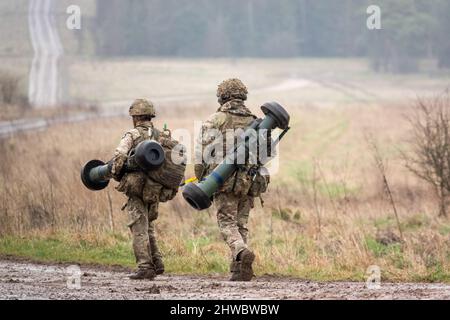 British army soldiers completing an 8 mile combat fitness test tabbing exercise with 40Kg bergen and NLAW (MBT-LAW, RB-57) anti-tank guided missile Stock Photo