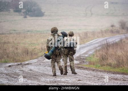 British army soldiers completing an 8 mile combat fitness test tabbing exercise with 40Kg bergen and NLAW (MBT-LAW, RB-57) anti-tank guided missile Stock Photo