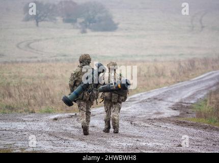 British army soldiers completing an 8 mile combat fitness test tabbing exercise with 40Kg bergen and NLAW (MBT-LAW, RB-57) anti-tank guided missile Stock Photo