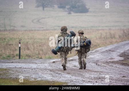 British army soldiers completing an 8 mile combat fitness test tabbing exercise with 40Kg bergen and NLAW (MBT-LAW, RB-57) anti-tank guided missile Stock Photo