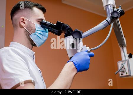 A young scientist conducting research with a microscope. Working with a microscope. Stock Photo