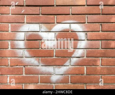 White heart painted on red brick wall. Love concept. Stock Photo