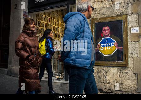 Barcelona, Spain. 5th Mar, 2022. Commuters look at a graffiti by Italian urban artist 'TVBoy', Salvatore Benintende, titled 'Stop The Madness' depicting Ukrainian president Volodymyr Zelensky holding a Stop sign in the national colors in protest to the ongoing Russian attacks Credit: Matthias Oesterle/Alamy Live News Stock Photo