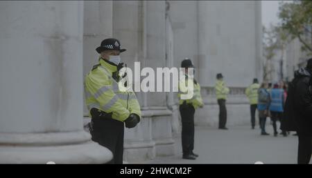 London, UK - 11 20 2021:  Police officer on duty wearing face mask, standing outside the Royal Courts of Justice on Strand, Insulate Britain protest. Stock Photo