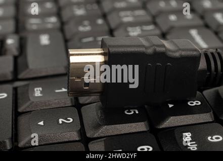 hdmi cable lies on a wireless keyboard close-up. TV connection cable Stock Photo