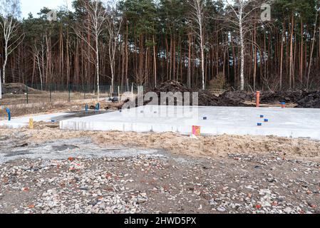 Poured concrete foundation plate made of reinforcing bars, sewer pipes visible. Stock Photo