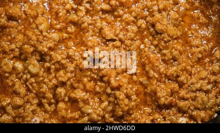 Close-up of meat stewed in sauce. Concept. Minced meat is well fried in large amount of sauce in pan. Professional cooking of minced meat gravy with s Stock Photo