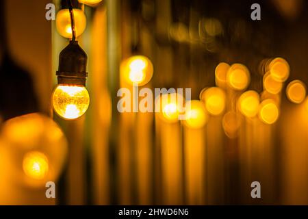 Decor Hanging Yellow Orange Light Lamp With Blurred lamp light Dark Night Background Stock Photo