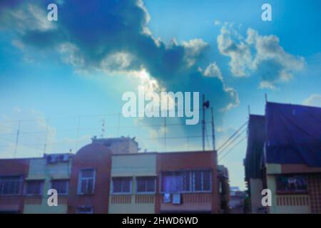 Blurred image of Kolkata cityscape , empty advertisement boards and hoardings with Sun, blue sky and white clouds in background. Stock Photo