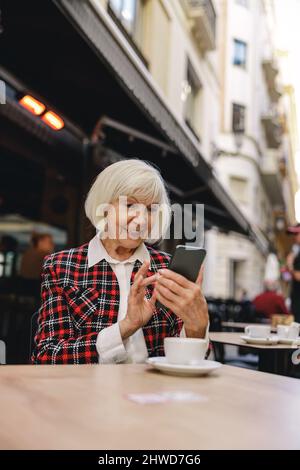 Photo of charming woman using smartphone outdoors Stock Photo