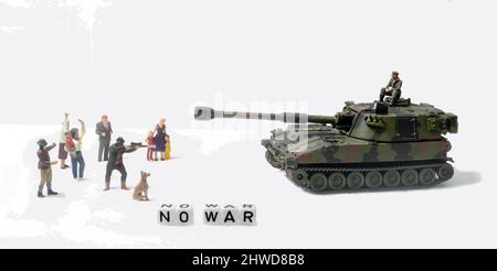 No War, miniature figurines stand in front of a tank and soldier, in an attempt to stop the tank, one figurine is pointing a rifle at the tank, Stock Photo