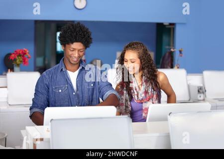 Doing the laundry together. A young couple at the laundromat. Stock Photo