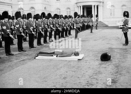 A hard days work for actor Richard Warwick who is playing Bumbo Bailey in the film 'The Breaking of Bumbo' which is being shot at Pinewood Studios. Bumbo is a young officer in the Brigade of Guards stationed at Wellington Barracks, and while on parade he faints and falls onto mattresses, but getting up and falling down can be hard work so during a break Richard has a quick lie down in his dressing room. 10th March 1970. Stock Photo