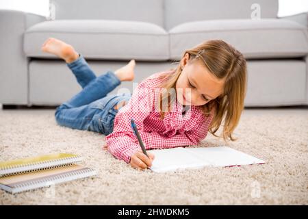 Cute little girl at home studying Stock Photo