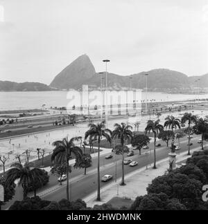 Sugarloaf Mountain on the shores of Rio de Janeiro, Brazil, December 1969. In foreground, local highways and a football match being played. Stock Photo