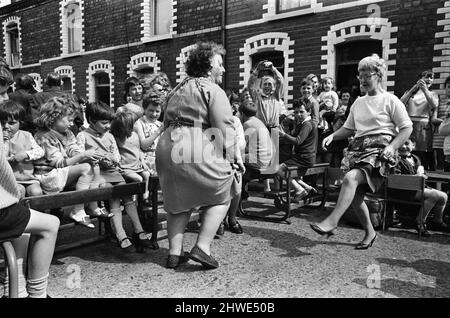 Street party in Balkan Street, Belfast. The party was organised after the street was hit by riot just a week ago after fighting broke out following the army discovering a cache of arms in the road. The party was organised for the children who had to stay in their homes because of a curfew imposed during the riots. 12th July 1970. Stock Photo