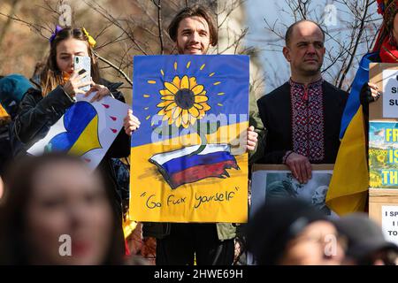 Manchester, UK. 05th Mar, 2022. Protester holds up a placard expressing his opinion while standing on a wall, during the demonstration. Thousands show up in Manchester Piccadilly Gardens to show support and solidarity for those suffering in Ukraine. Schoolchildren held up banners and had their faces painted while others spoke on the steps of the Queen Victoria Statue. Credit: SOPA Images Limited/Alamy Live News Stock Photo