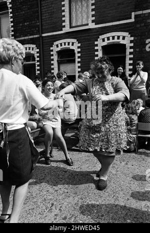 Street party in Balkan Street, Belfast. The party was organised after the street was hit by riot just a week ago after fighting broke out following the army discovering a cache of arms in the road. The party was organised for the children who had to stay in their homes because of a curfew imposed during the riots. 12th July 1970. Stock Photo