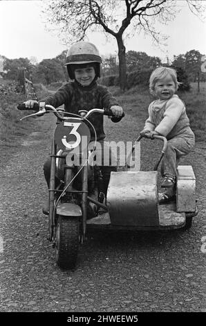 Jim Whitt of Tipton, Staffs, is a well-known motorcycle 'scrambler' both round the Midland circuits and the Continent. His greatest fan is his four-year-old son Craig. who wants to one day emulate him. Jim has built a 50cc machine which Craig handles with ease and his little sister, 16-month-old Mandy, loves to ride as passenger, leaning over to help the machine round corners. 1st June 1969. Stock Photo