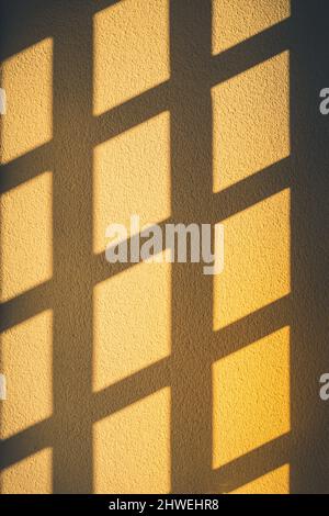 Abstract window shadows on the yellow wall. Stock Photo