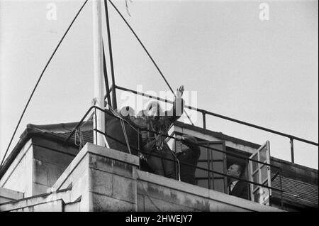 22 year old student Ann Warren climbed to the top of Rhodesia House, took down the rebel smith regime flag and replaced it with the Union Jack. Pictured, Ann waves to the crowd in The Strand below as she leaves the roof of Rhodesia House. At 5pm she took the Union Jack down and eventually came on to The Strand pavement for a press conference and a kiss from her boyfriend, Ian Middlehurst, who was one of the two men who spent a Sunday perched in the same position earlier in the month. 27th January 1969. Stock Photo